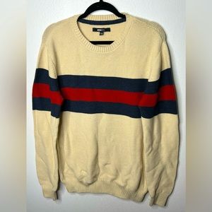 A cream colored sweater with blue and red stripes